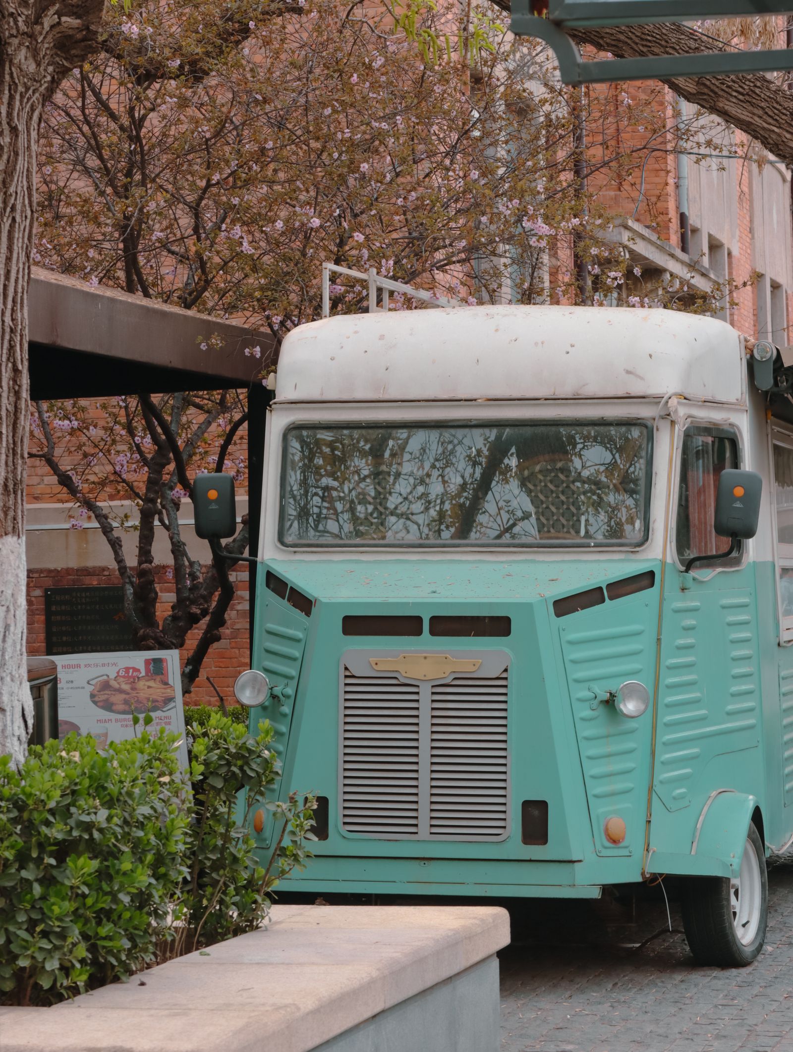 Vintage mint-green and white food truck parked on an urban street corner