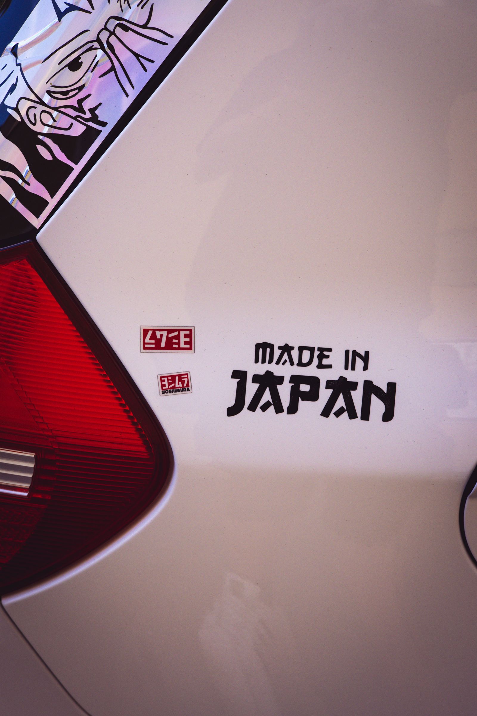 Close-up of cut vinyl decals applied to a car's rear panel