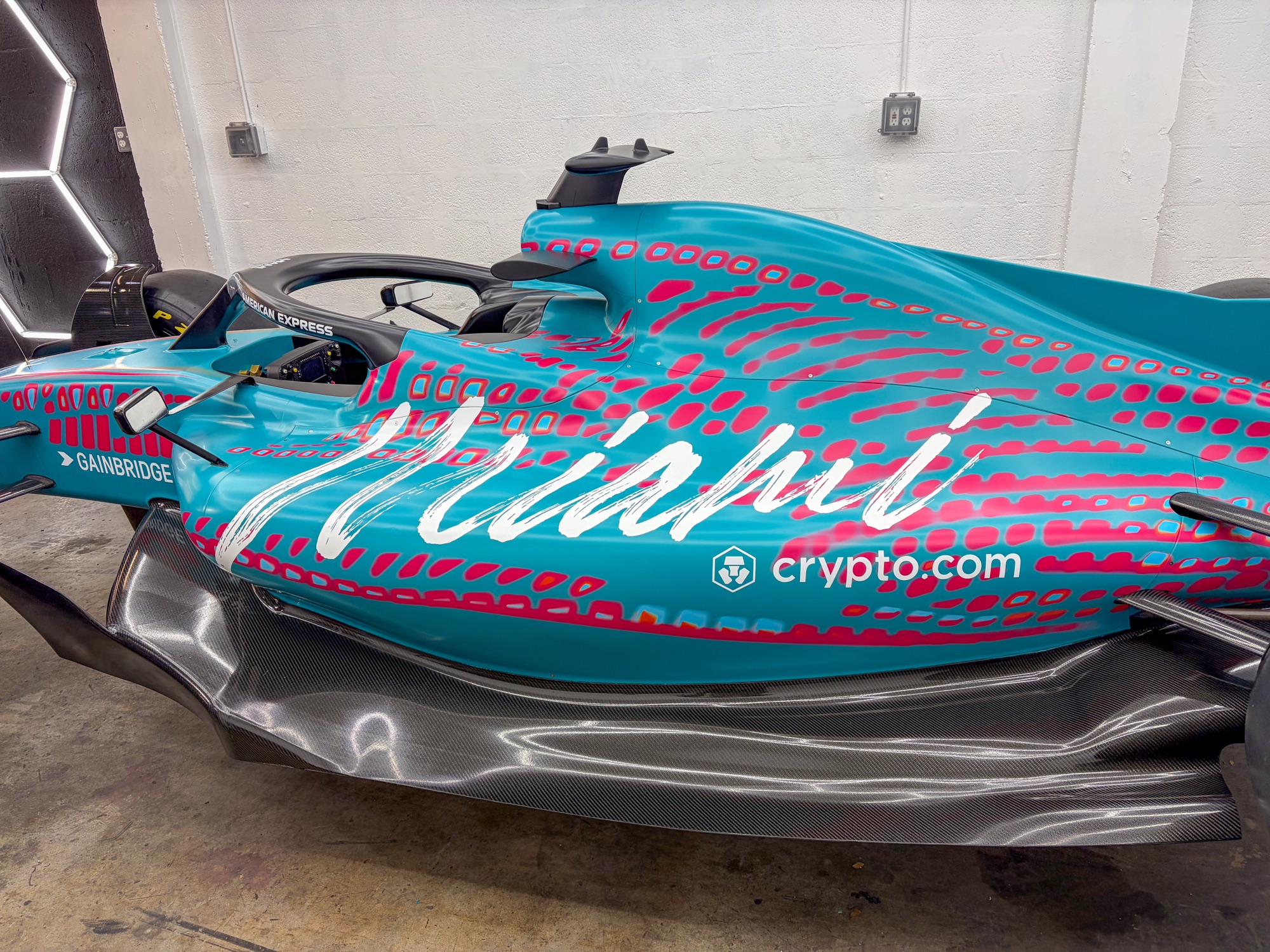 Full side profile of the wrapped F1 car showing the Miami script