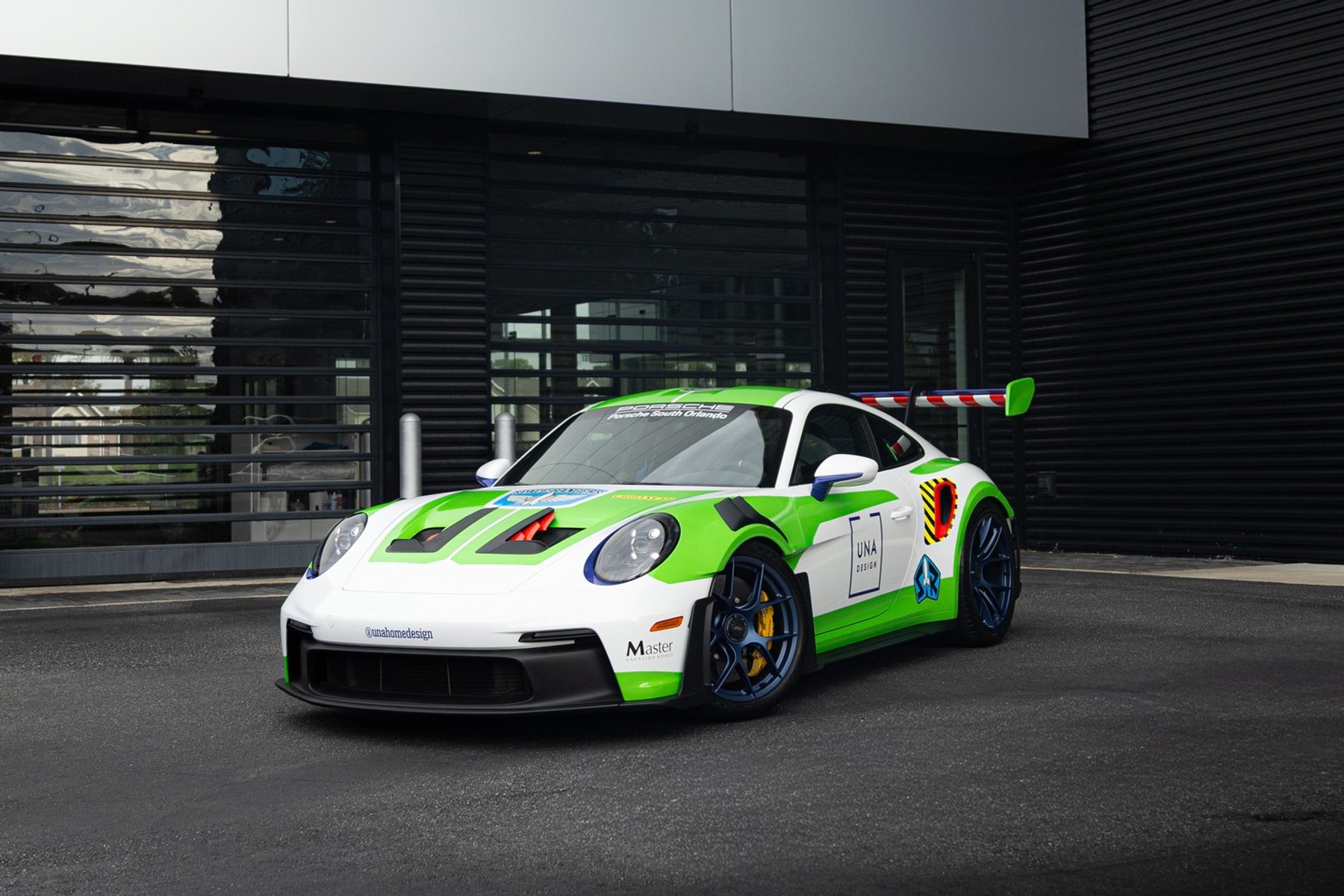 Porsche 911 GT3 RS wrapped in a green, white, and blue custom livery, front three-quarter view