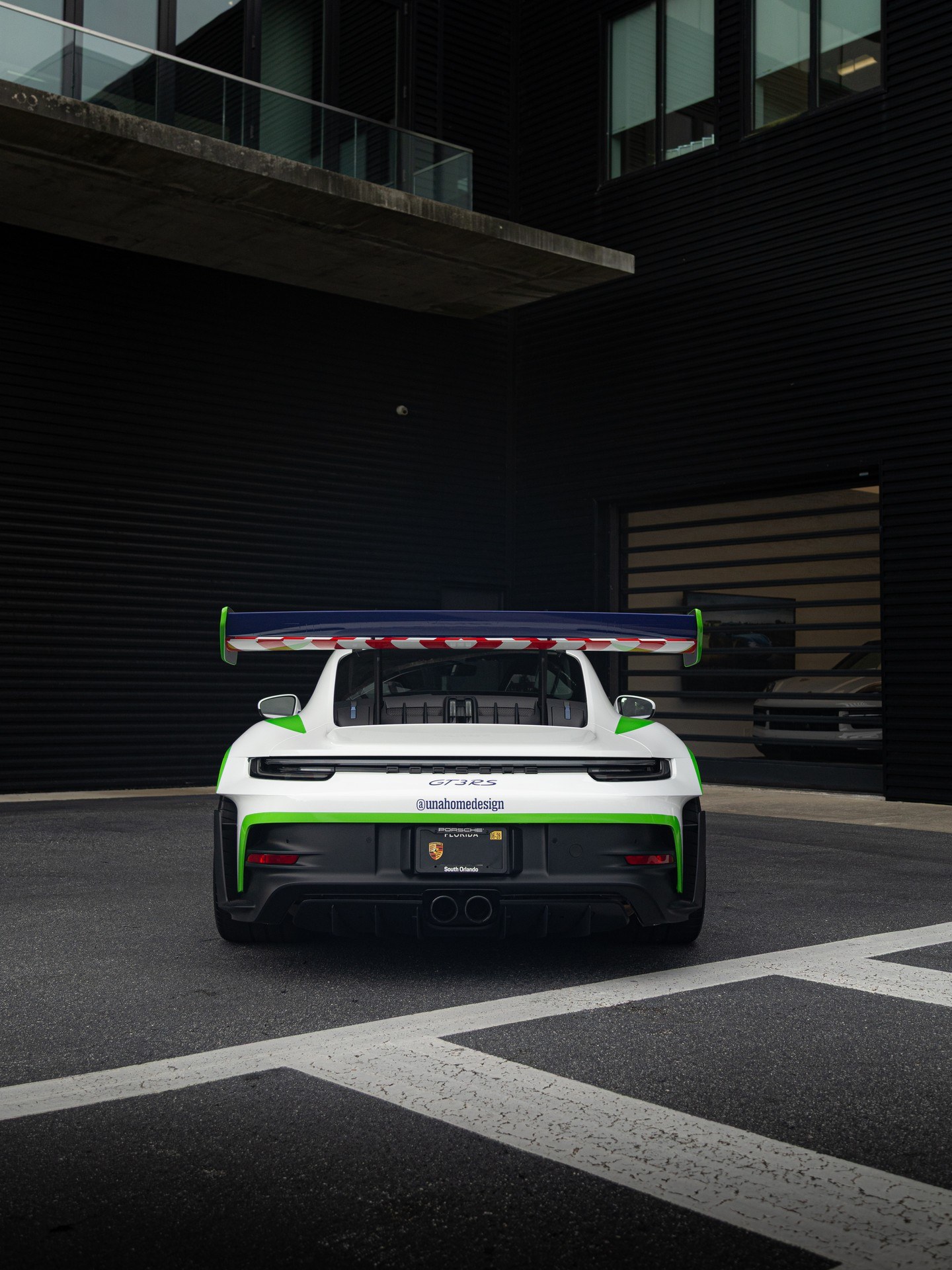 Rear view of the wrapped GT3 RS showing the full livery and wing