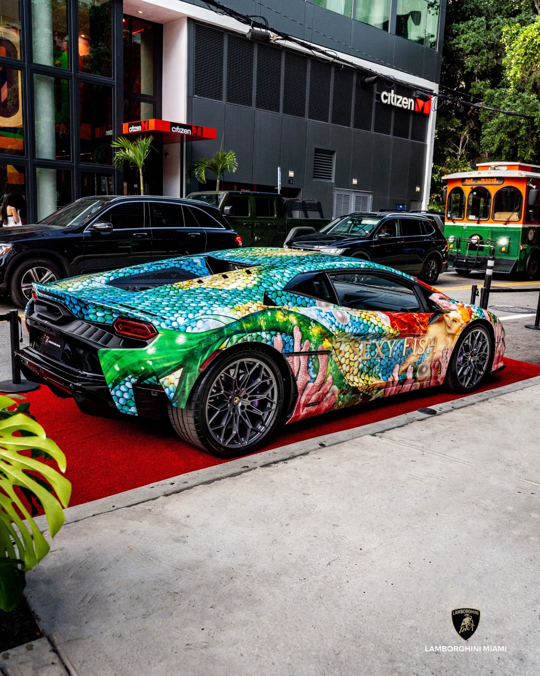 Sexy Fish Lamborghini parked outside citizenM Brickell with a Miami trolley passing